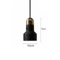 Industrial style black iron chandelier light hanging above a wooden bar table.