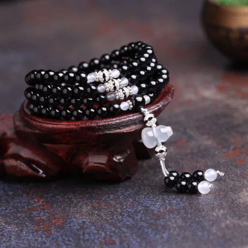 Black and red agate stone bracelet with 108 geometric beads on a wrist