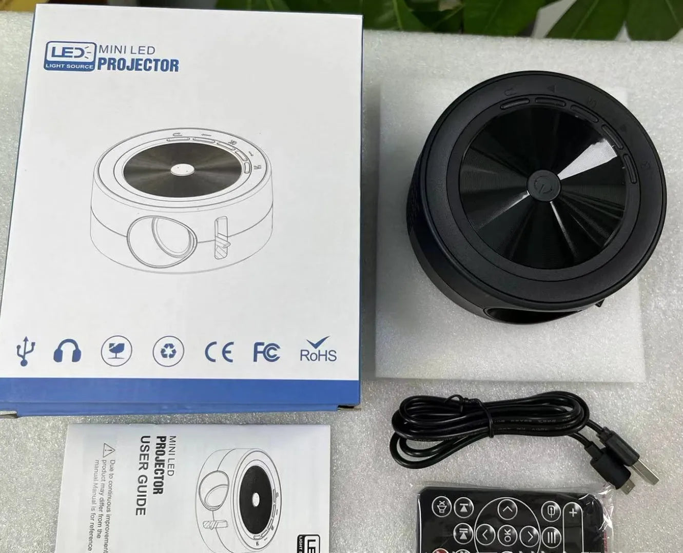 YT200 compact portable LED projector in black, white, yellow/white, or blue/white with USB cord and remote control