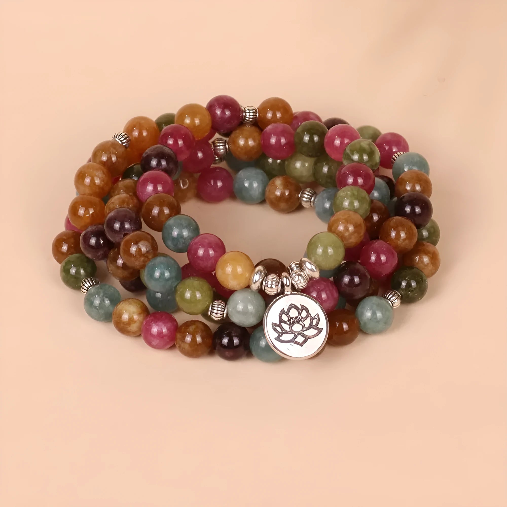 108 bead multi-strand bracelet with natural tourmaline stones and alloy clasp on a wrist.