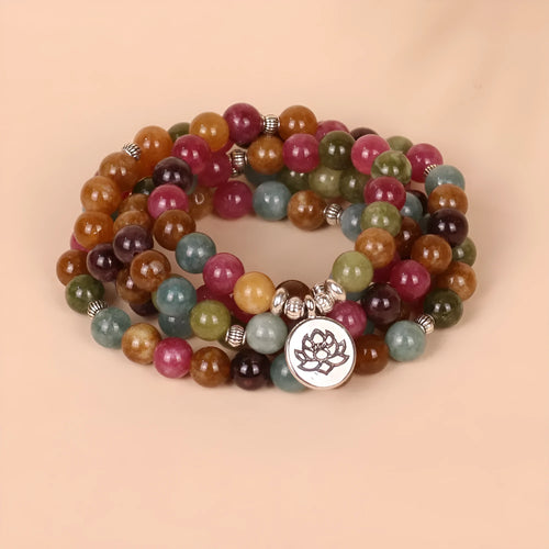108 bead multi-strand bracelet with natural tourmaline stones and alloy clasp on a wrist.