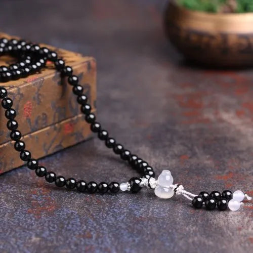 Black and red agate stone bracelet with 108 geometric beads on a wrist