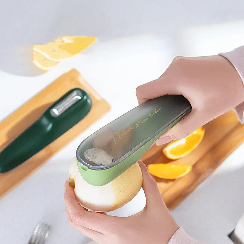 Dark green kitchen peeler with storage tube showing stainless steel blade and hanging hole