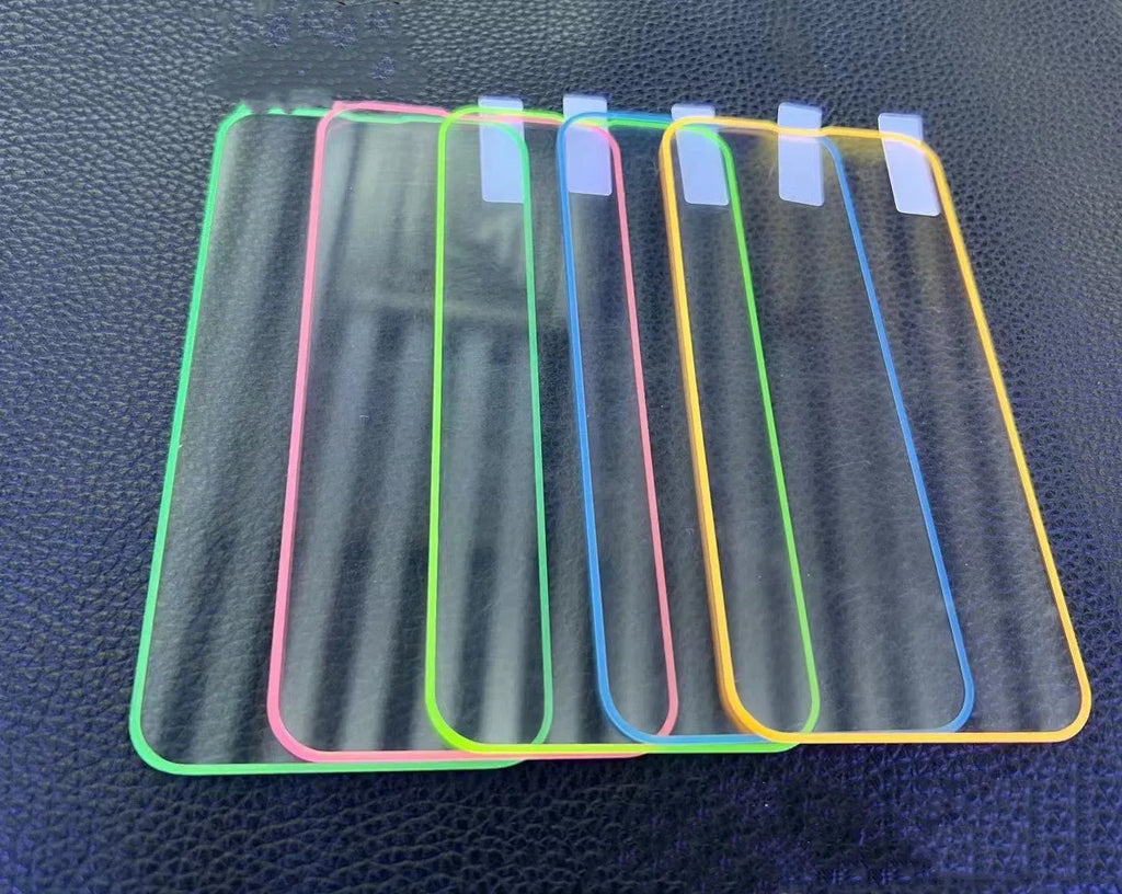 Fluorescent pink luminous tempered glass screen protector applied on an iPhone 13, glowing softly in a dark setting.