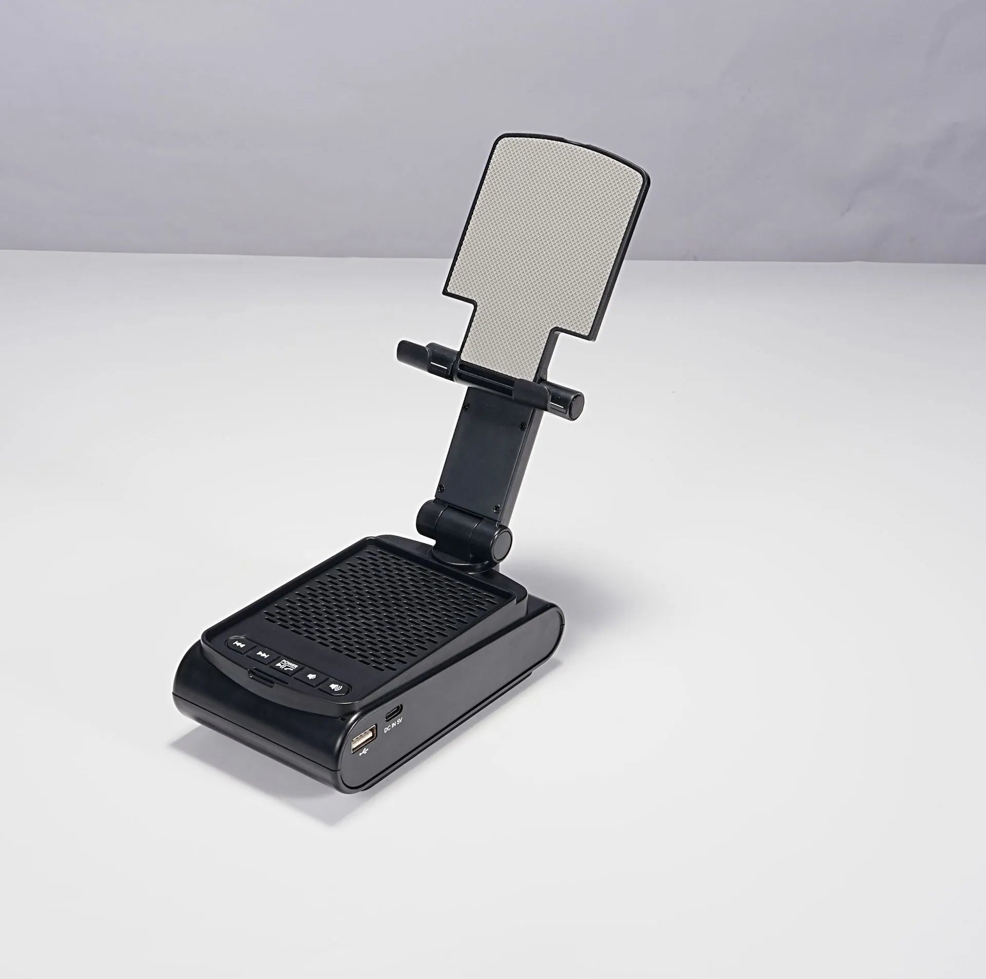 Multi-function plastic lazy phone holder with built-in Bluetooth speaker, USB powered, black colour, showing phone in stand