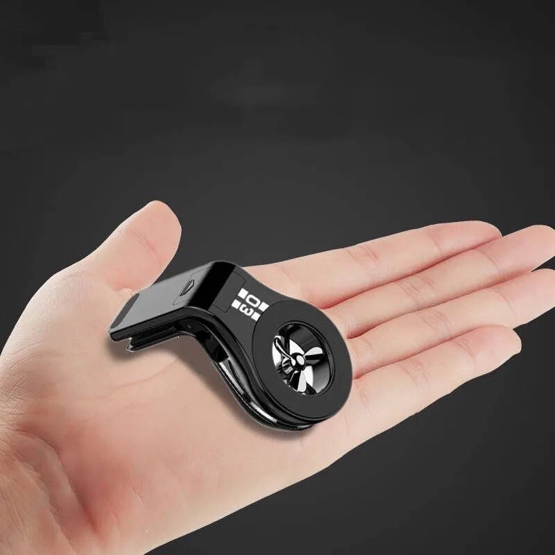 Black magnetic phone holder clipped onto a car air vent, showing phone attached and 360-degree rotation.