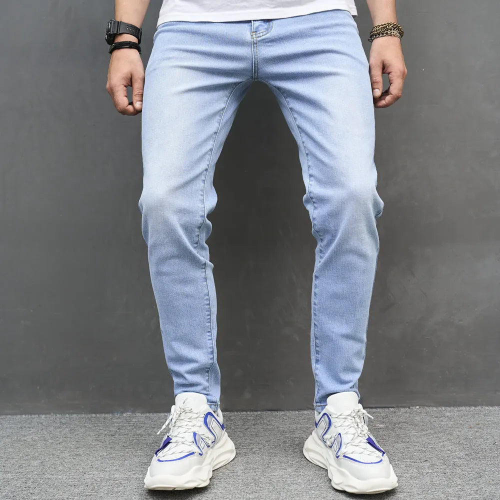Light blue skinny cotton stretch men's jeans with mid waist and tapered leg on model