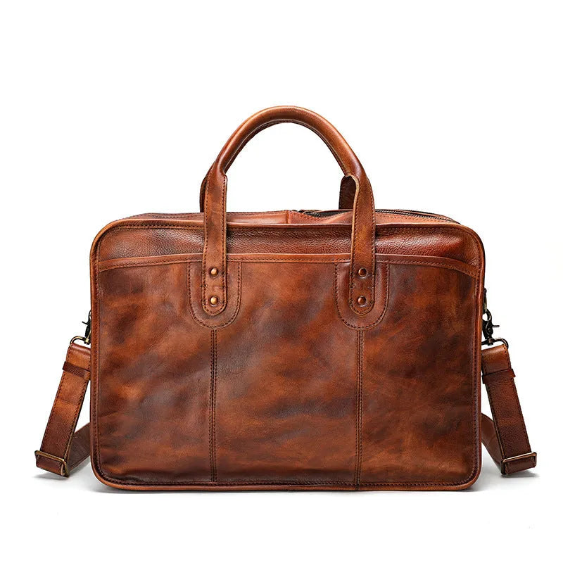 Brown vintage leather men's briefcase with soft handle, showing organised internal pockets for laptop and camera.
