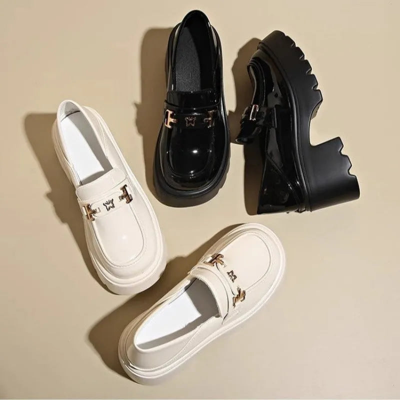 Black leather slip-on shoes with chunky square heel, round toe, and skull pattern design.
