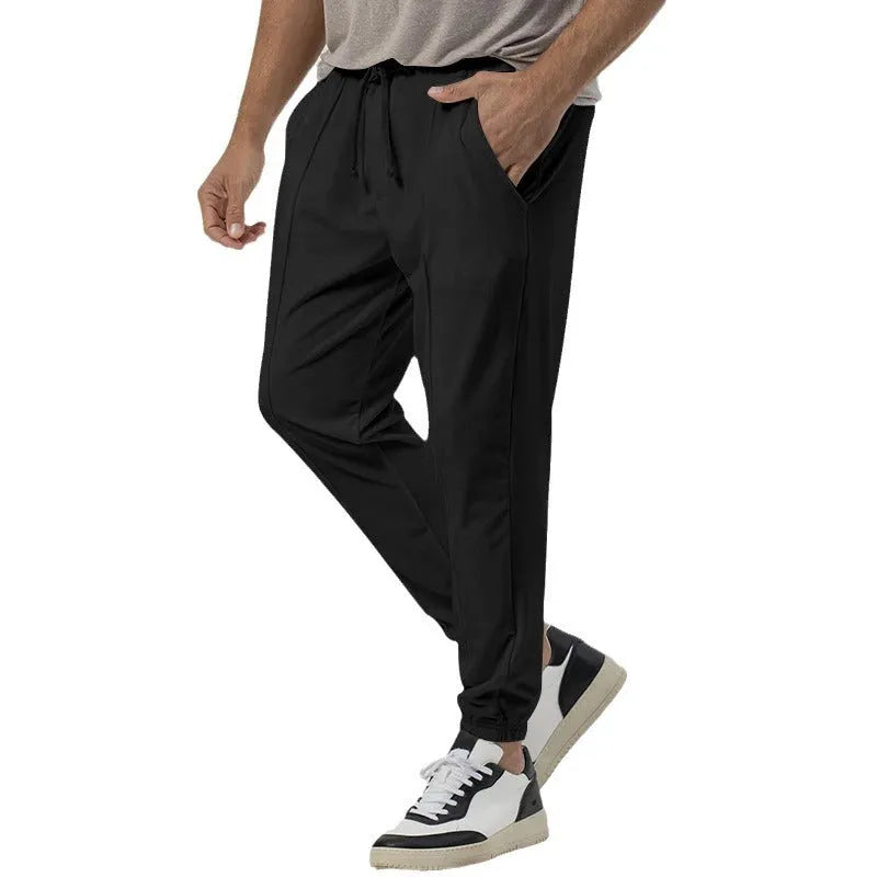 Man wearing grey straight-leg casual track sweatpants with an elasticated waist and micro-elastic fabric.