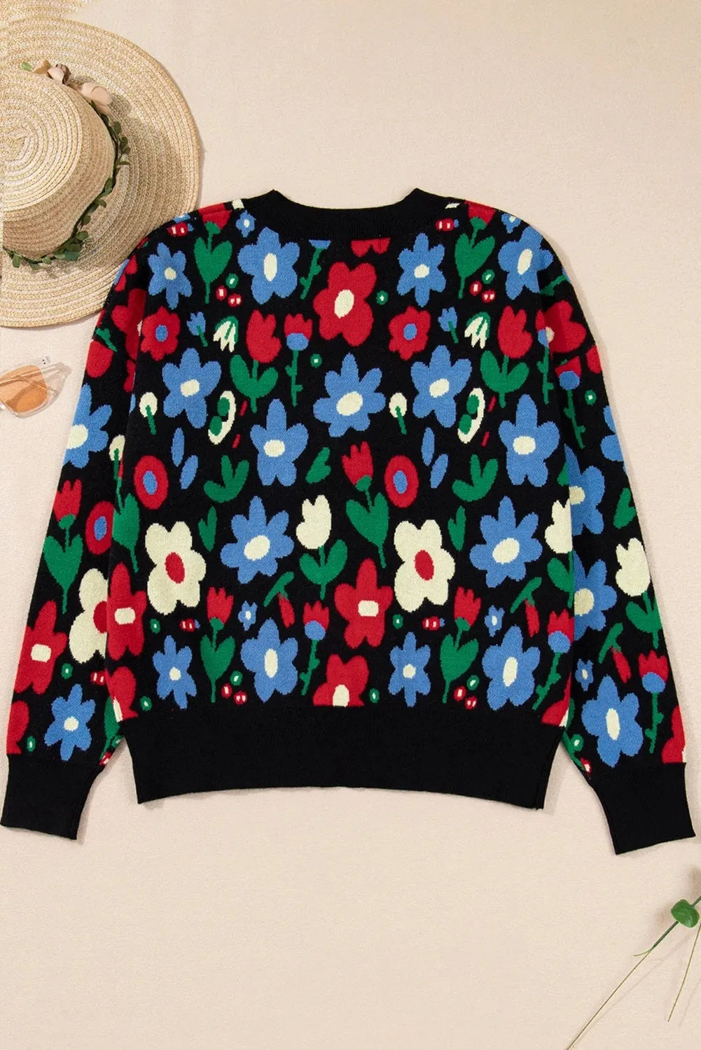 Black floral print V-neck button cardigan sweater with long sleeves and colour-block detail, laid flat
