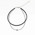 Retro leather rope double layer necklace with glass crystal beads and stainless steel buckle on a neutral background