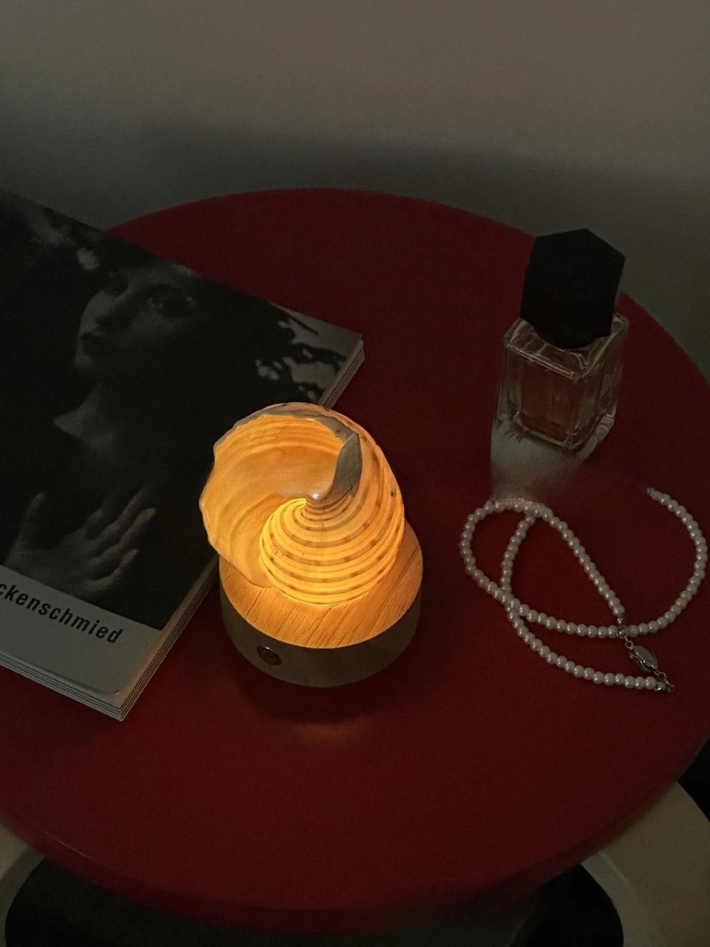 Creative natural conch shell small night lamp with USB charging cord on a table
