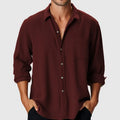 A man wearing a loose-fit, long-sleeve casual shirt with a stand collar, suitable for beach or holiday wear.