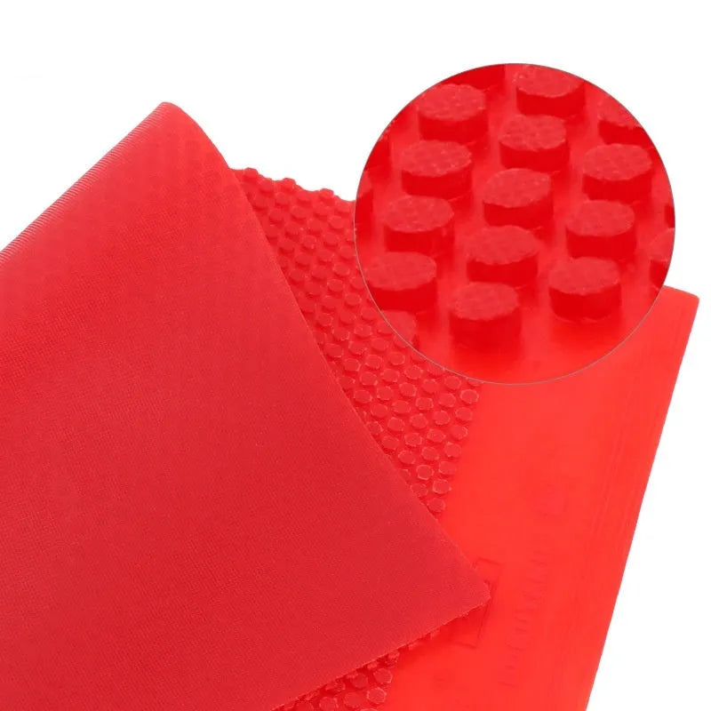 Single sheet of black and red raw rubber for table tennis rackets with a small pimple surface texture.