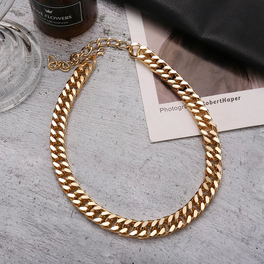 Gold thick chain women's necklace with large links, shown from the side on a plain background.
