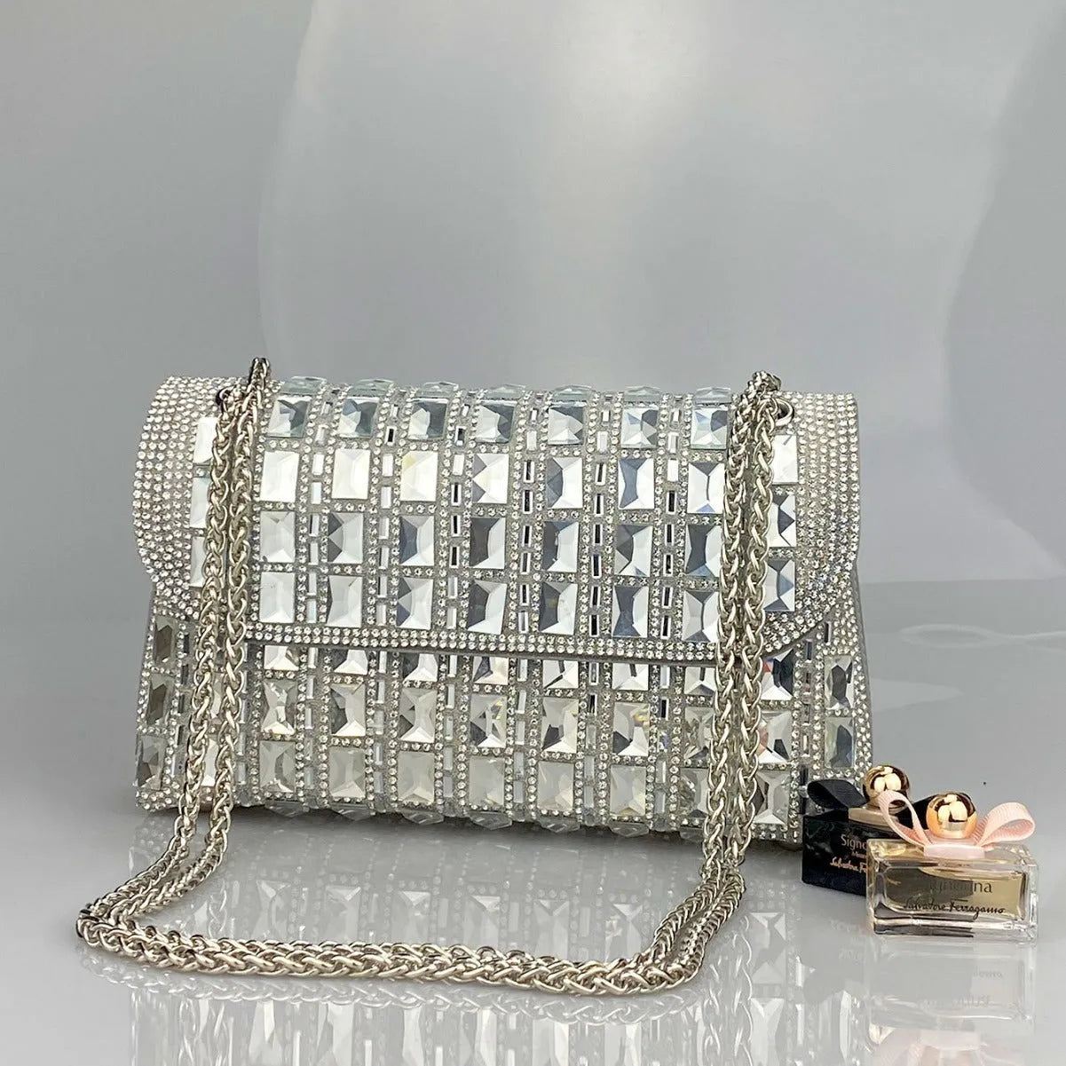 Glass rhinestone chain clutch bag in horizontal square shape with decorative diamonds and chain strap