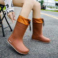 Women's solid colour PVC rain boots in apricot, black, brown, or pink with non-slip wear-resistant design