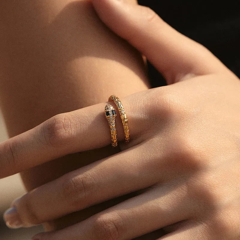 Snake-shaped adjustable copper ring with gold colour finish on a model's index finger.