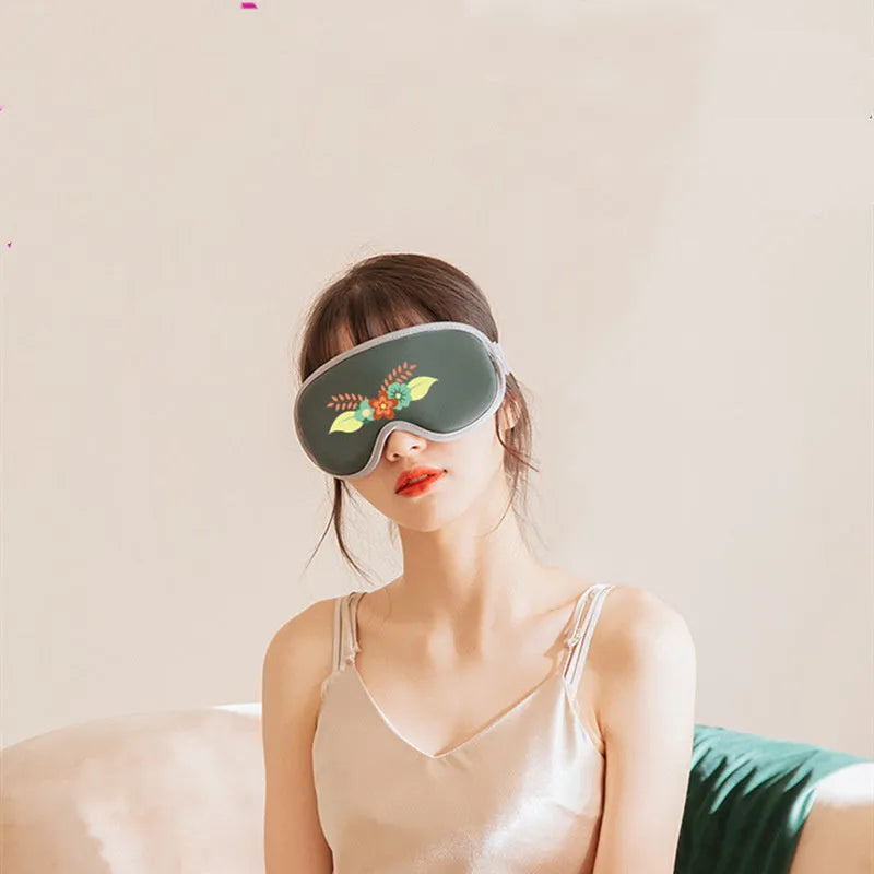 Pink portable eye SPA mask with steam and vibration massage functions on a grey background.