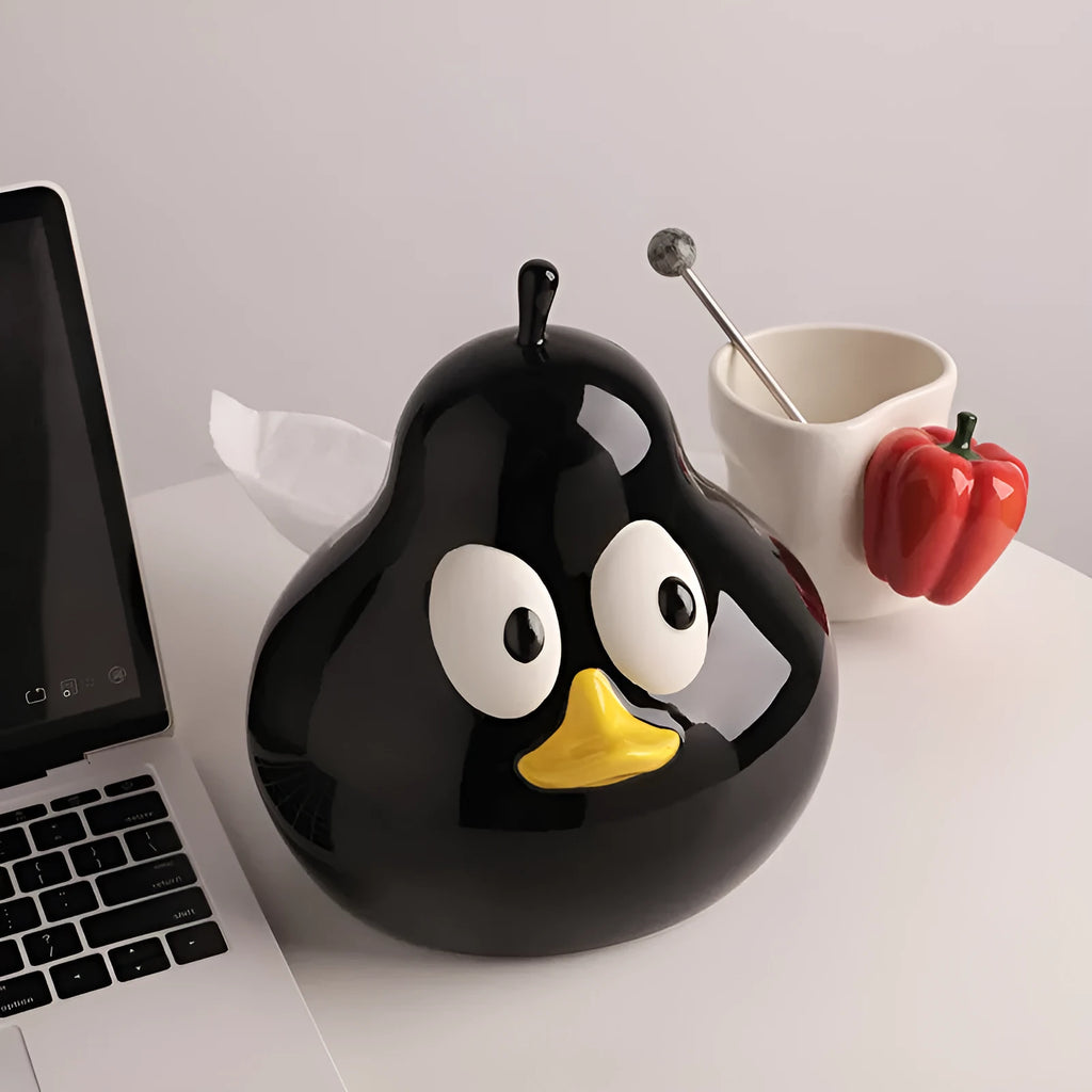 Green ceramic pear-shaped tissue box holder on wooden desk