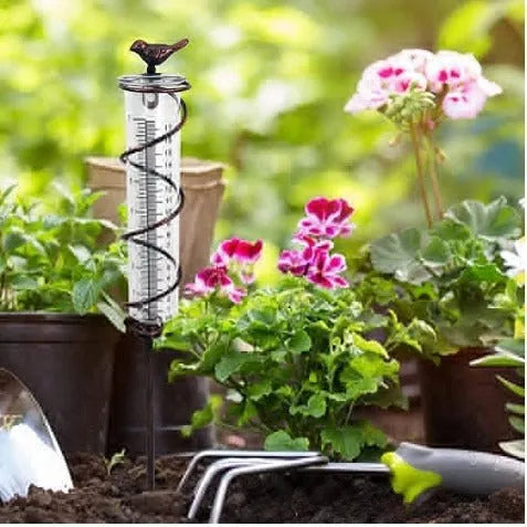 Cast iron hummingbird garden rain gauge with glass measurement tube showing 1-20 scale.