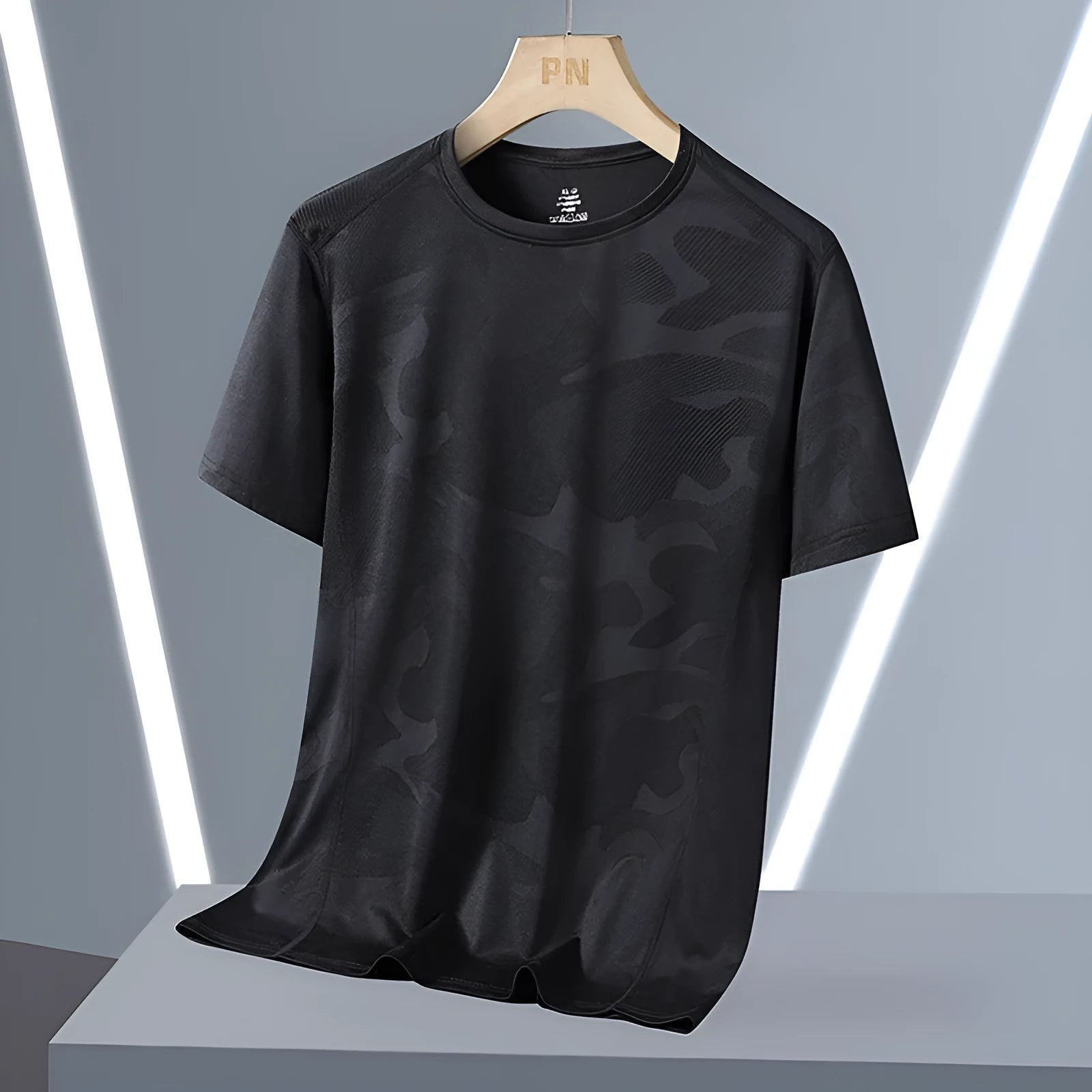 Man wearing a loose fit camouflage pattern short sleeve nylon t-shirt in Army Green.
