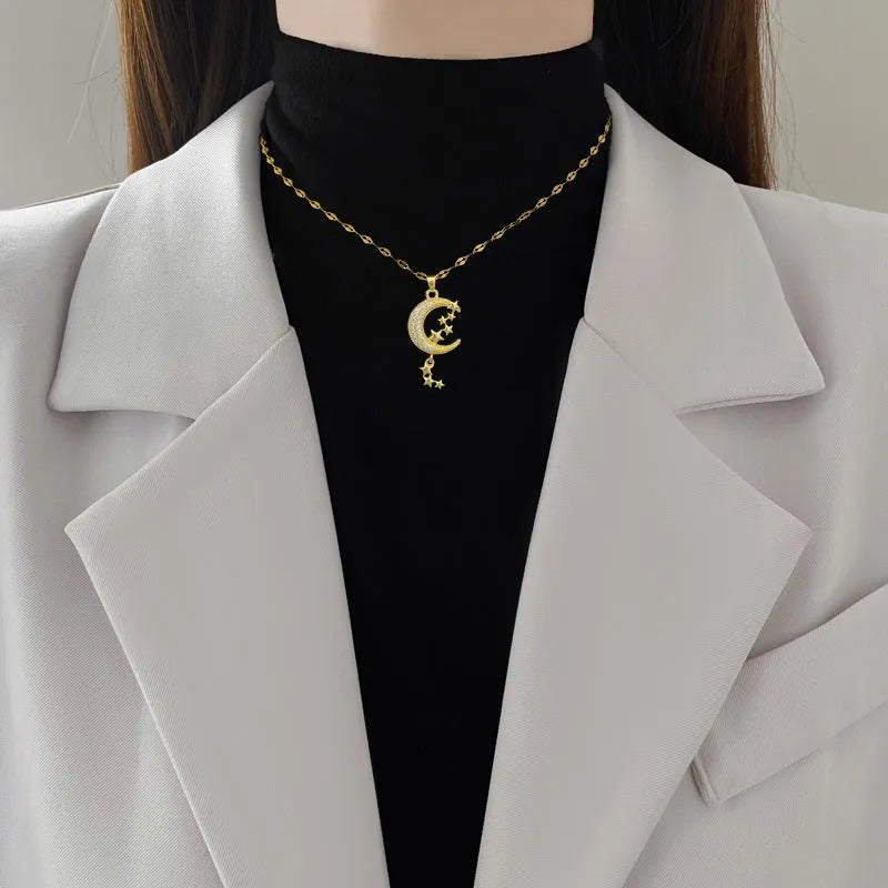 Geometric openwork moon pendant necklace with a linear crystal tassel on a silver stainless steel chain.