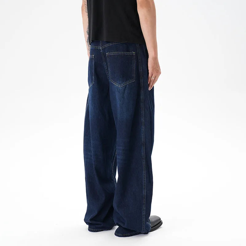 Dark blue washed distressed denim wide leg machete jeans laid flat, showing the wide leg cut and textured finish.