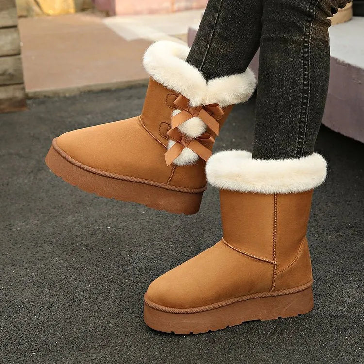 Women's suede ankle boots with fleece lining, flat heel, and bow detail in beige