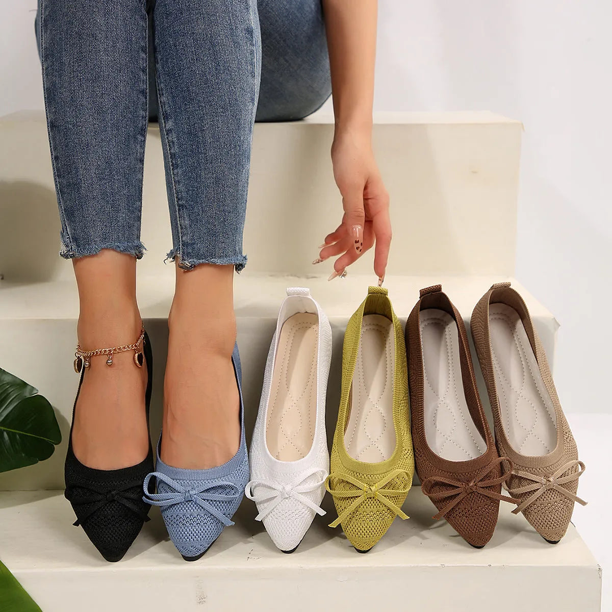 Women's blue knitted loafers with a bow detail and pointed toe on a flat rubber sole.