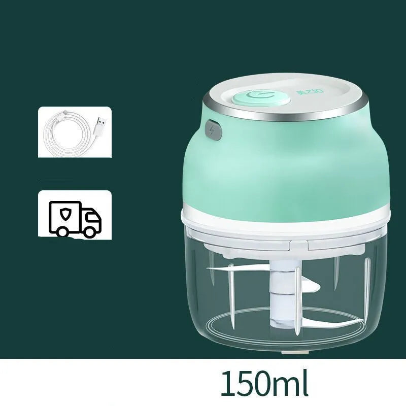 Portable electric mini garlic cutter with green body, transparent cup, and stainless steel blade on table