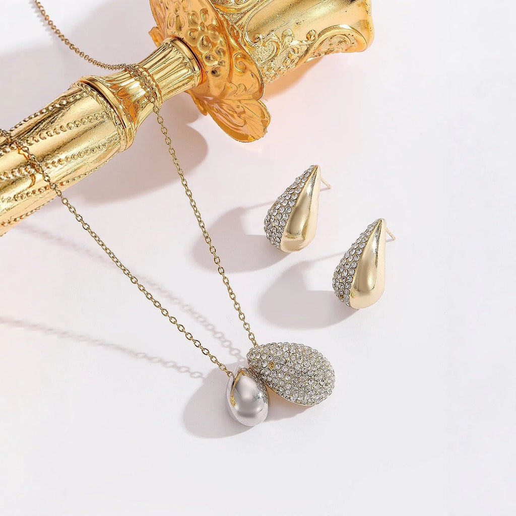 Elliptical necklace and earring set with full diamond droplet shape, silver-tone finish
