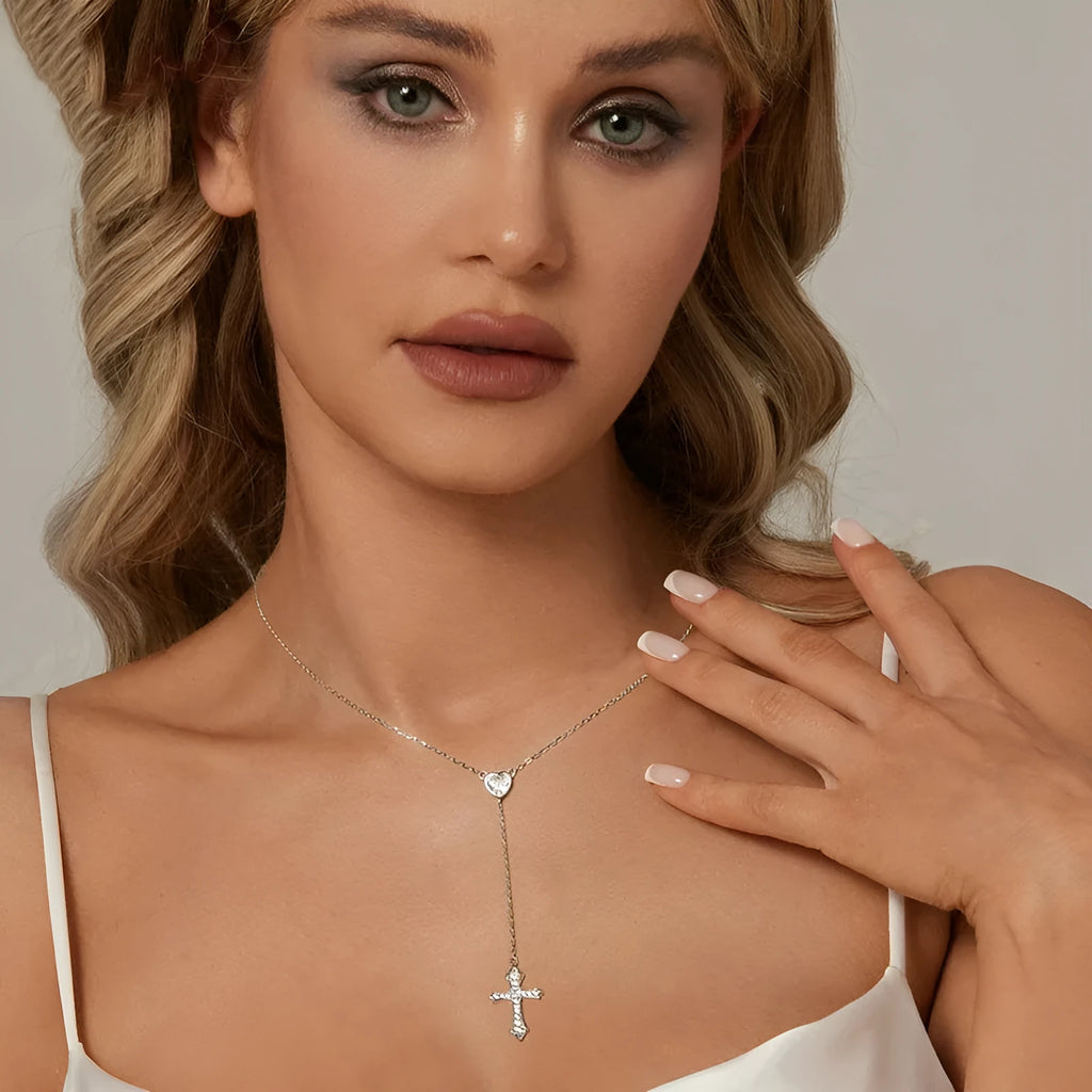Simple silver love cross pendant necklace with O-ring chain on a V-neck.