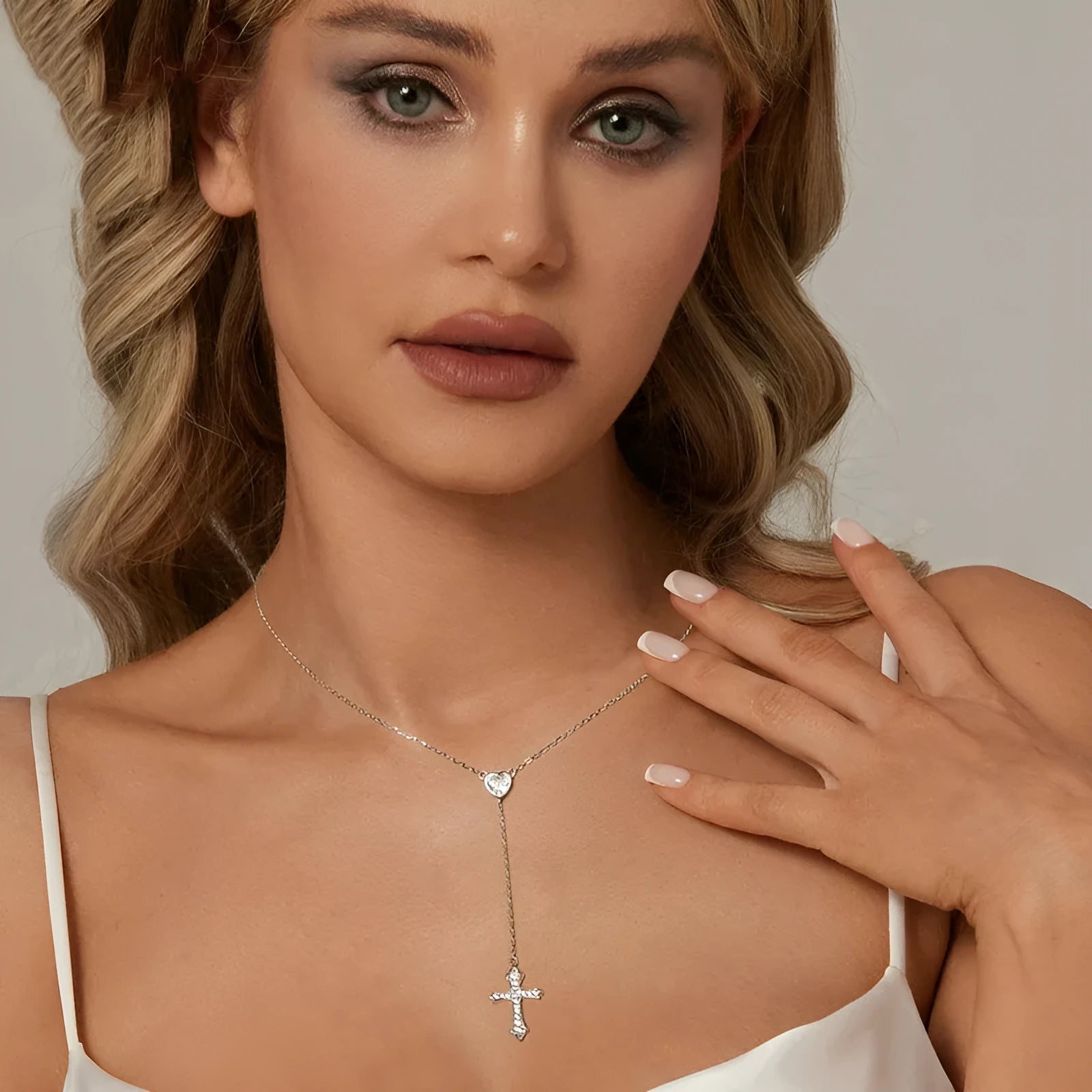 Simple silver love cross pendant necklace with O-ring chain on a V-neck.