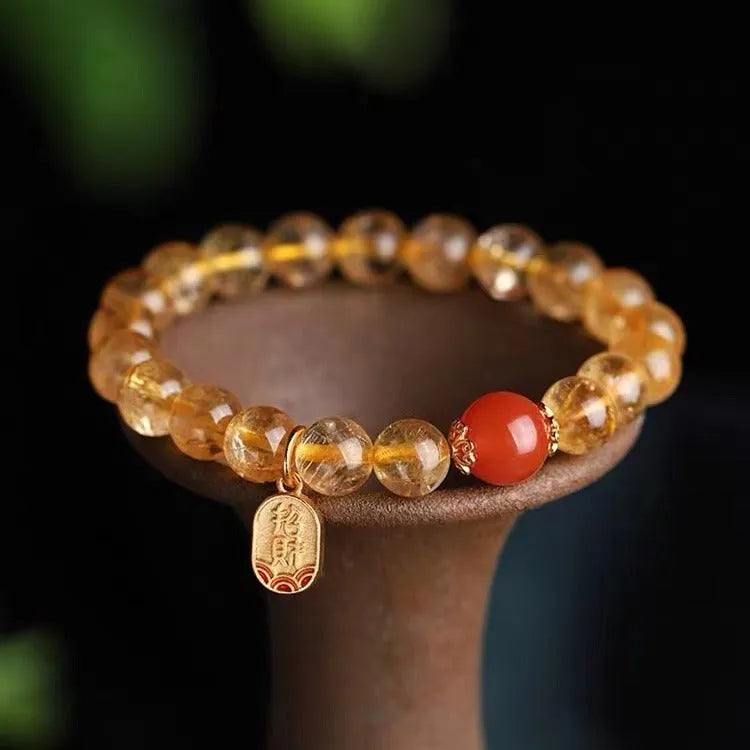 Natural red agate bead bracelet with gold ruby accents on a wrist, showing three bead size options.