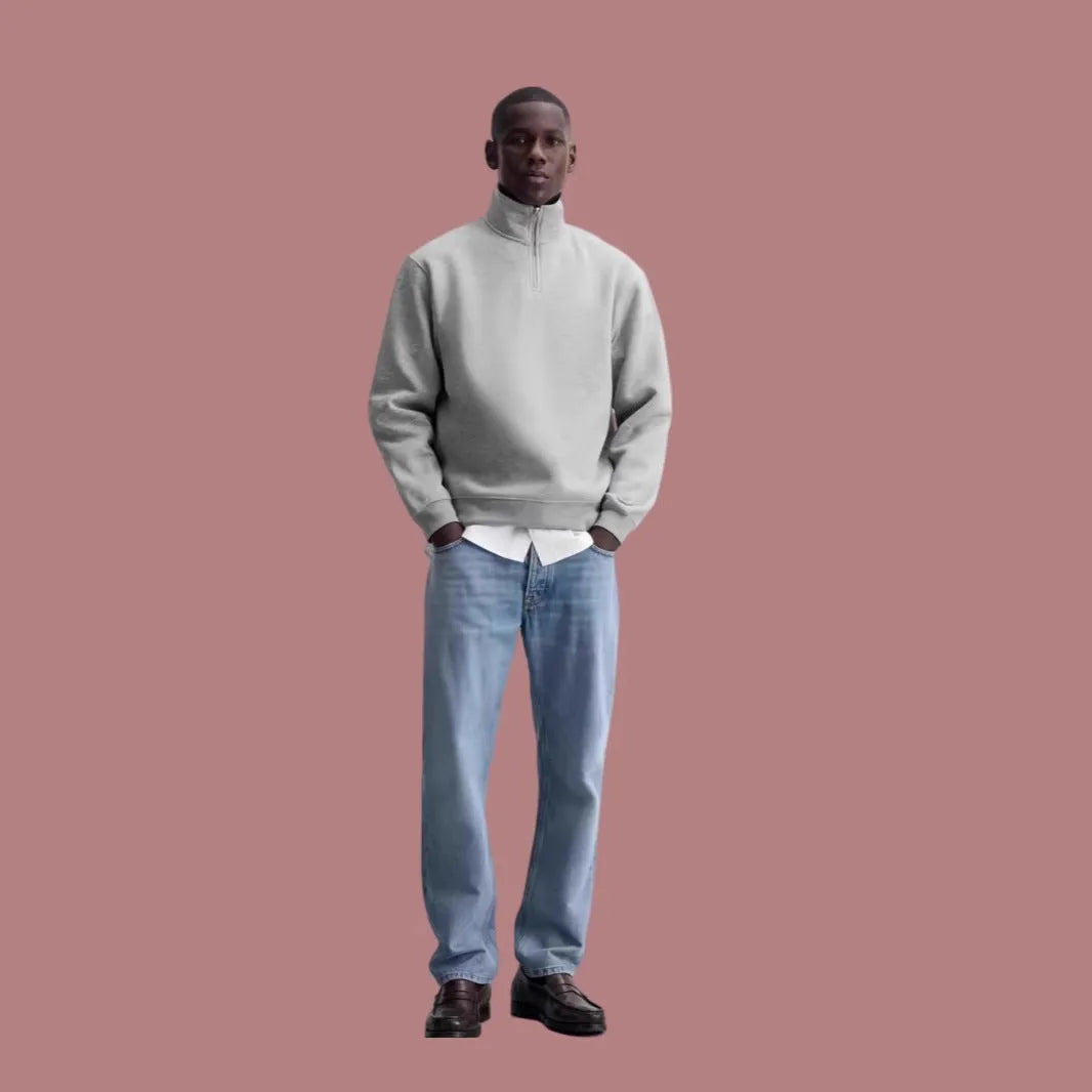 A grey half-zip stand collar cotton sweater laid flat, showing the front zip and long sleeves.