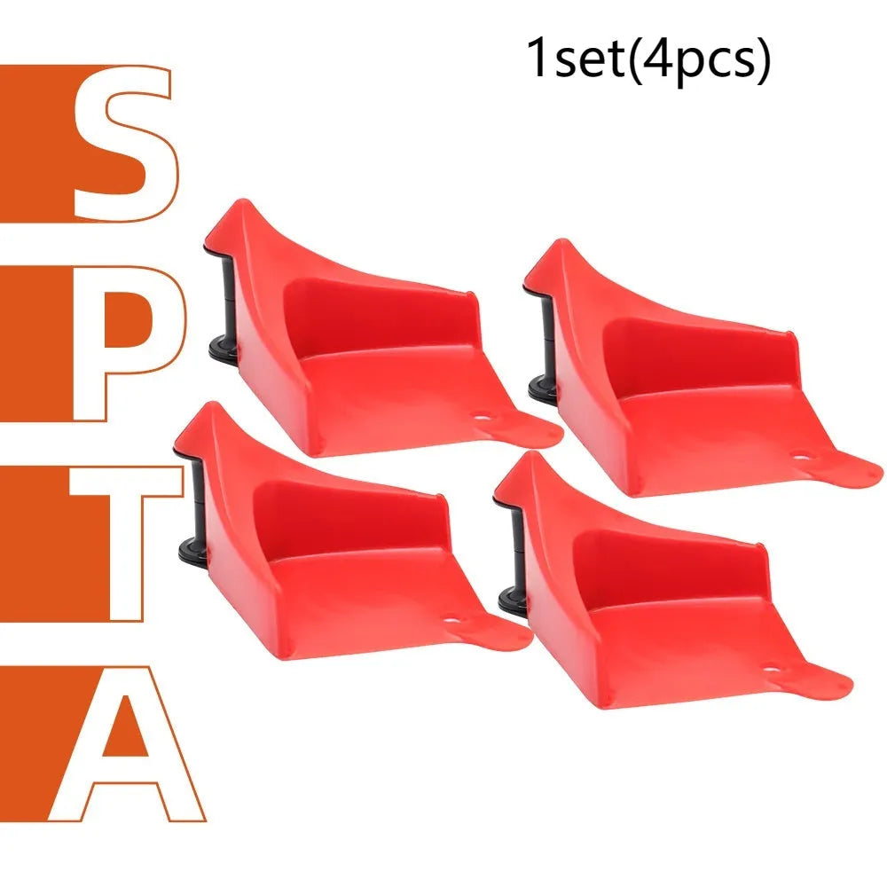 Set of four bright red triangular plastic car parking blocks on a surface.
