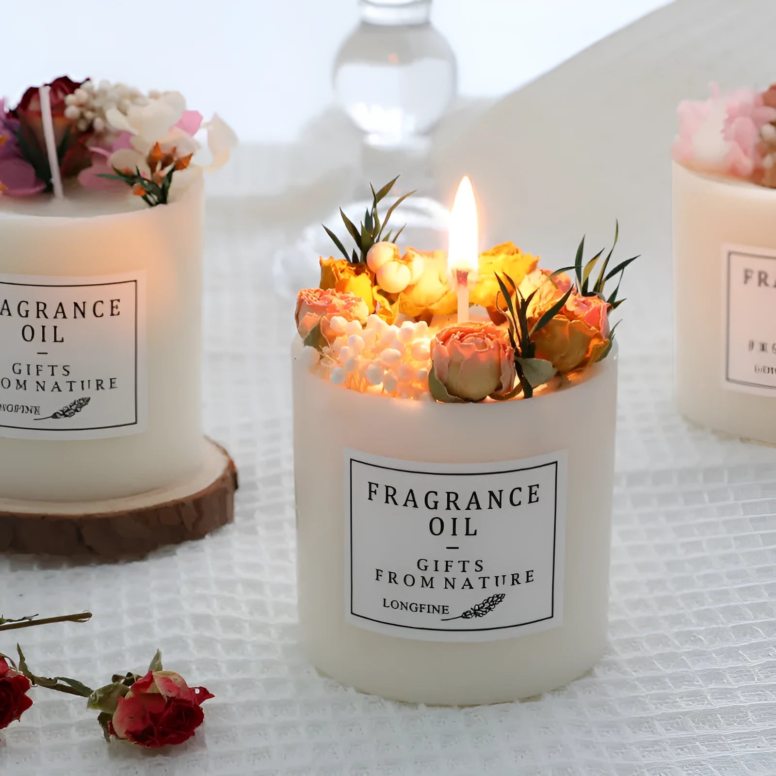 Decorative aromatherapy candle with dried flowers on a wood chip base, available in multiple scents.