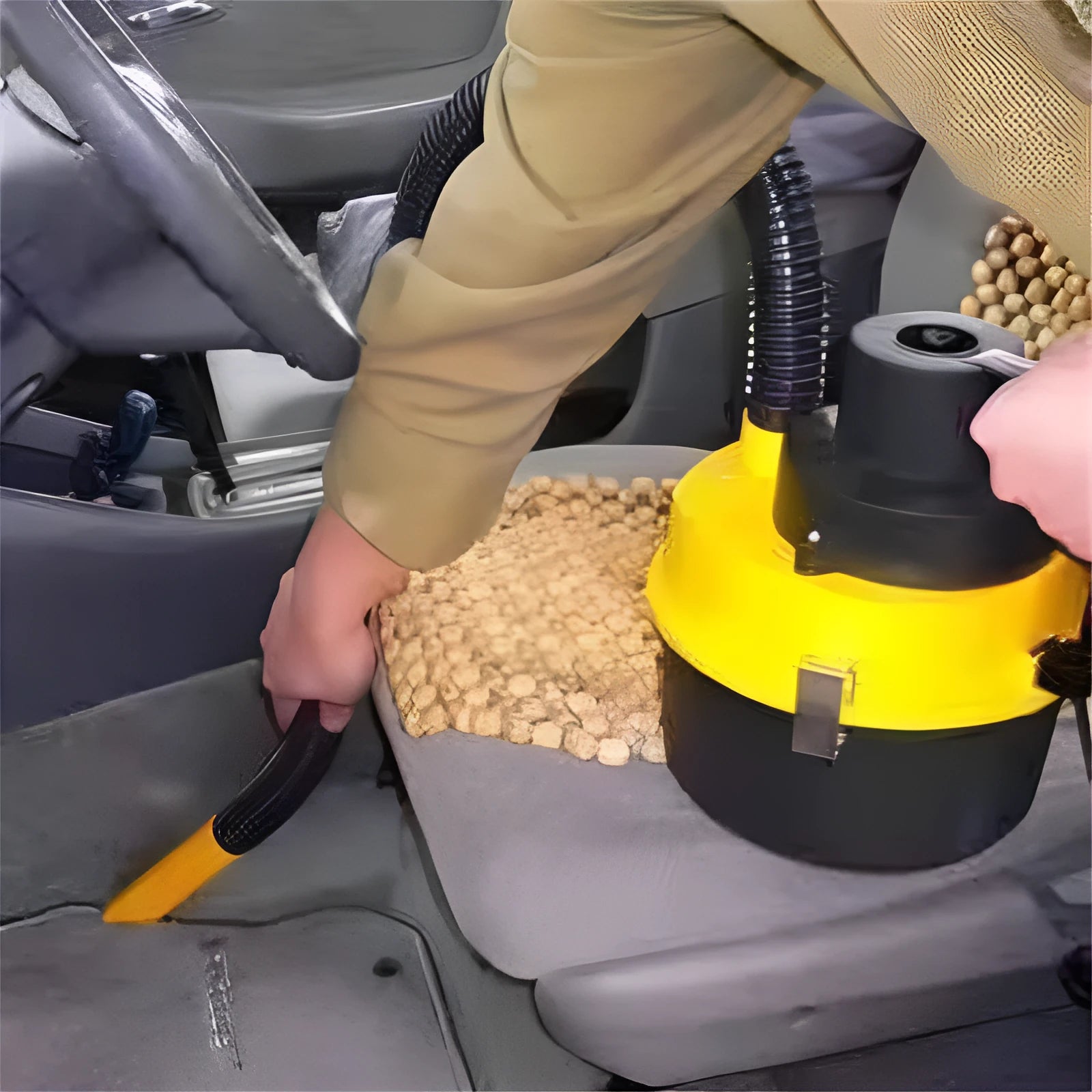 Car portable vacuum cleaner with high power 90W, red, with attachments including brush and hose on a car seat