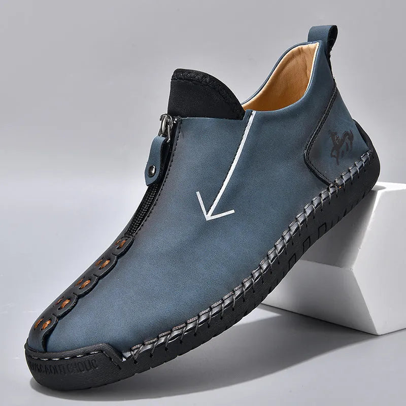 Men's black leather ankle boots with a front zipper and hand-stitched rubber sole.