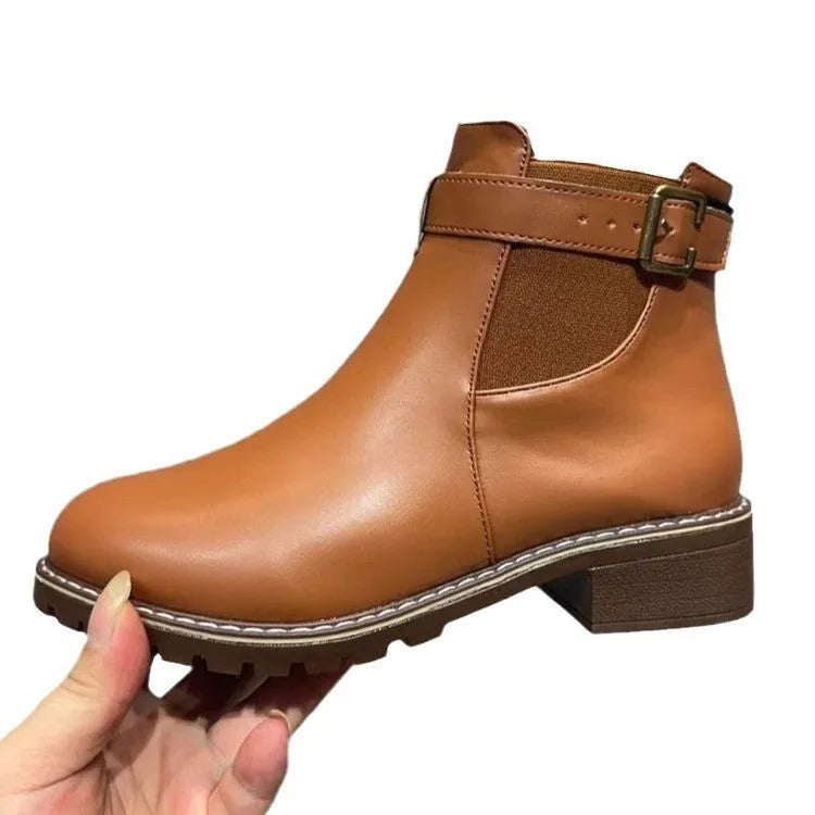 Black round toe women's ankle boot with a decorative metal belt buckle on the side.