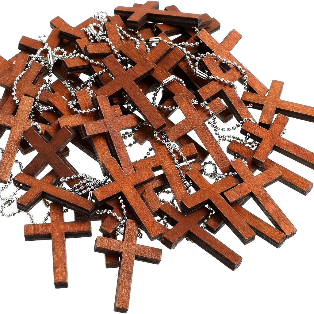 Wooden craft cross pendant ornament with natural wood finish, standing upright on a table
