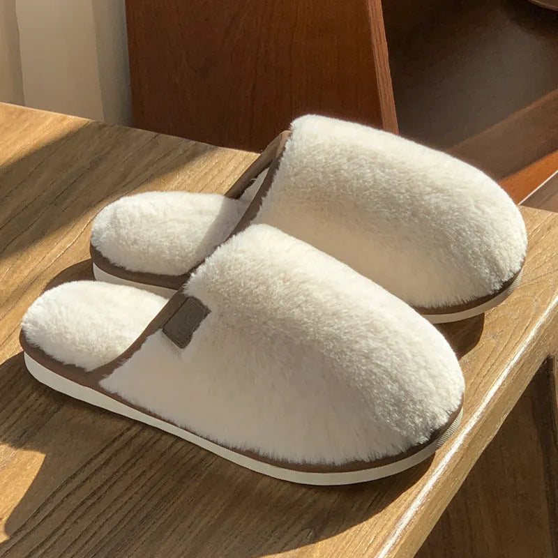 Pair of solid-colour plush winter slippers with a PVC upper and textured non-slip sole.