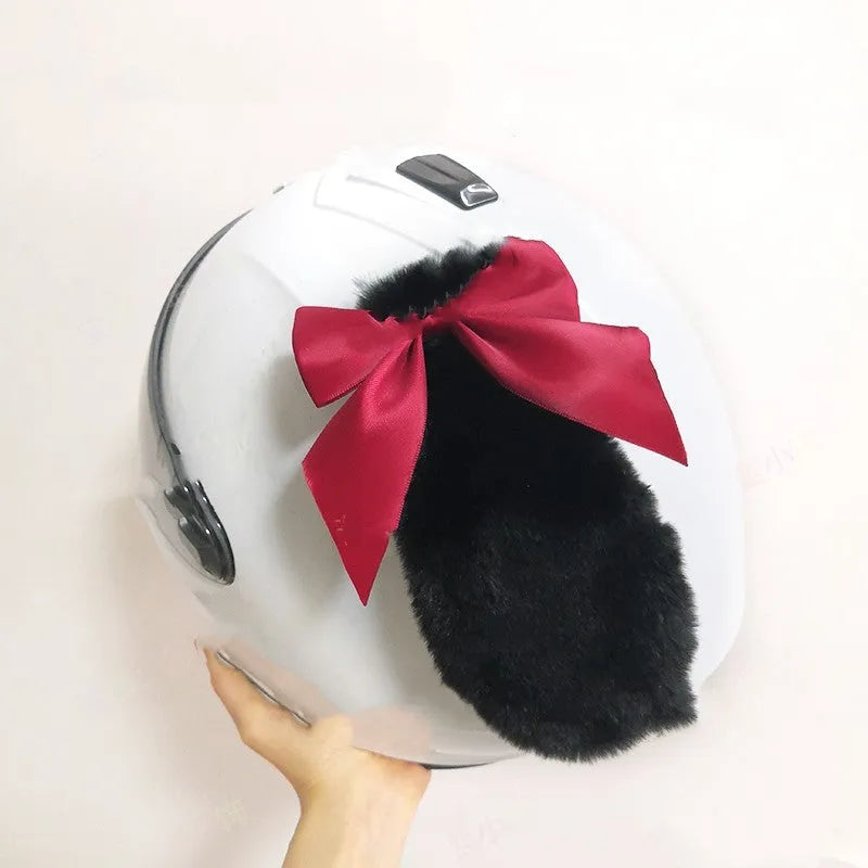 Carbon fibre rabbit ear decoration attached to a black motorcycle helmet, showing clip-on mechanism.
