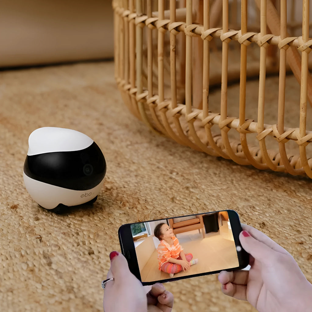 White smart home mobile robot camera on a charging dock.