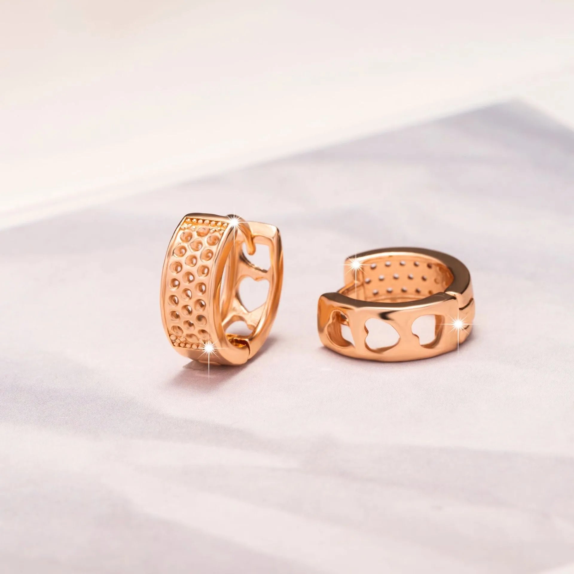 Rose gold women's earrings with a hollow heart shape featuring three cut-out sections.