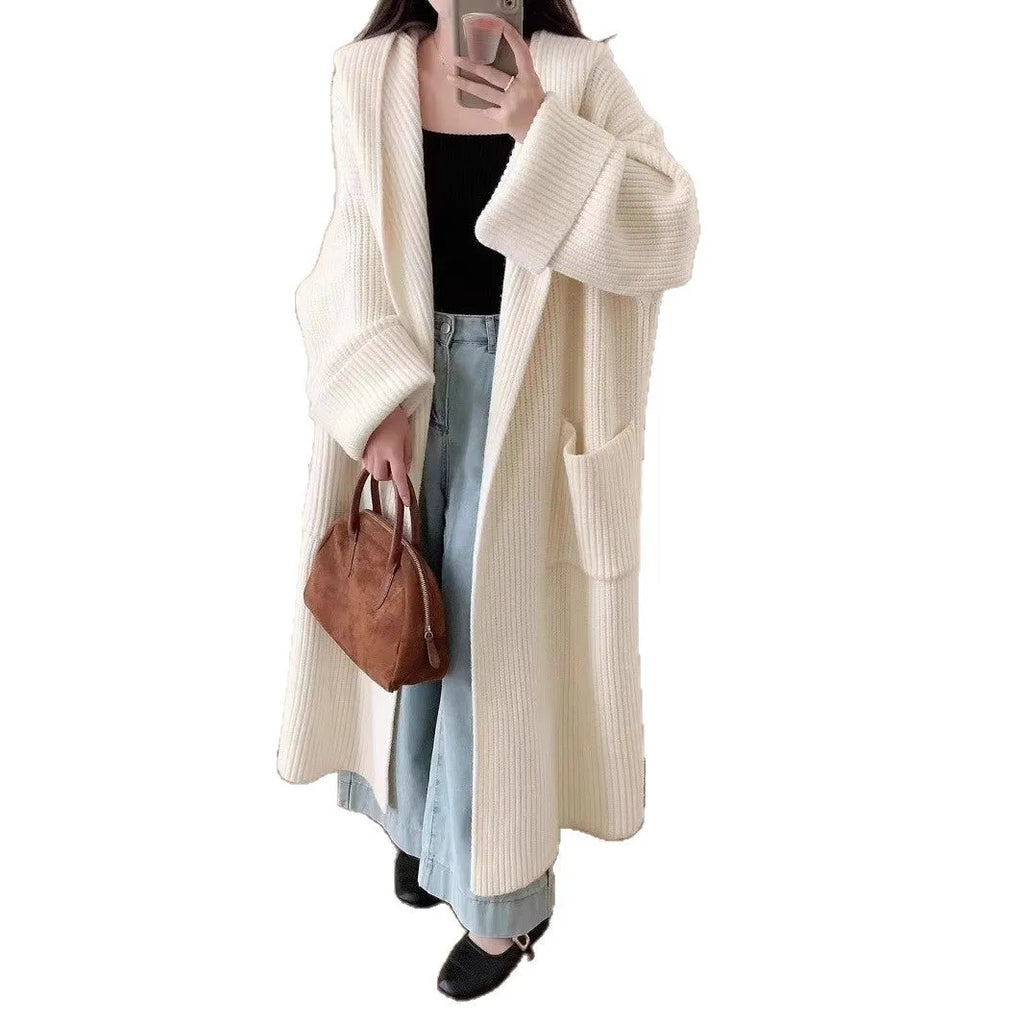 Woman wearing a long loose hooded cardigan coat in acrylic fabric, open as a cardigan.