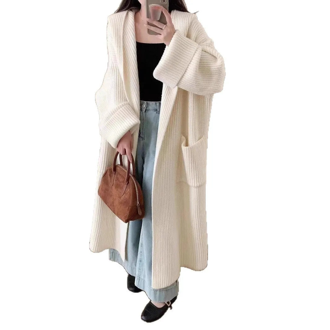 Woman wearing a long loose hooded cardigan coat in acrylic fabric, open as a cardigan.