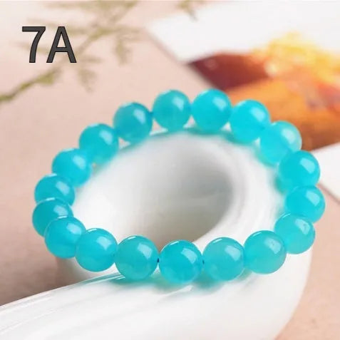 Polished natural Amazonite scattered beads in blue-green tones, shown loose and on a bracelet cord.